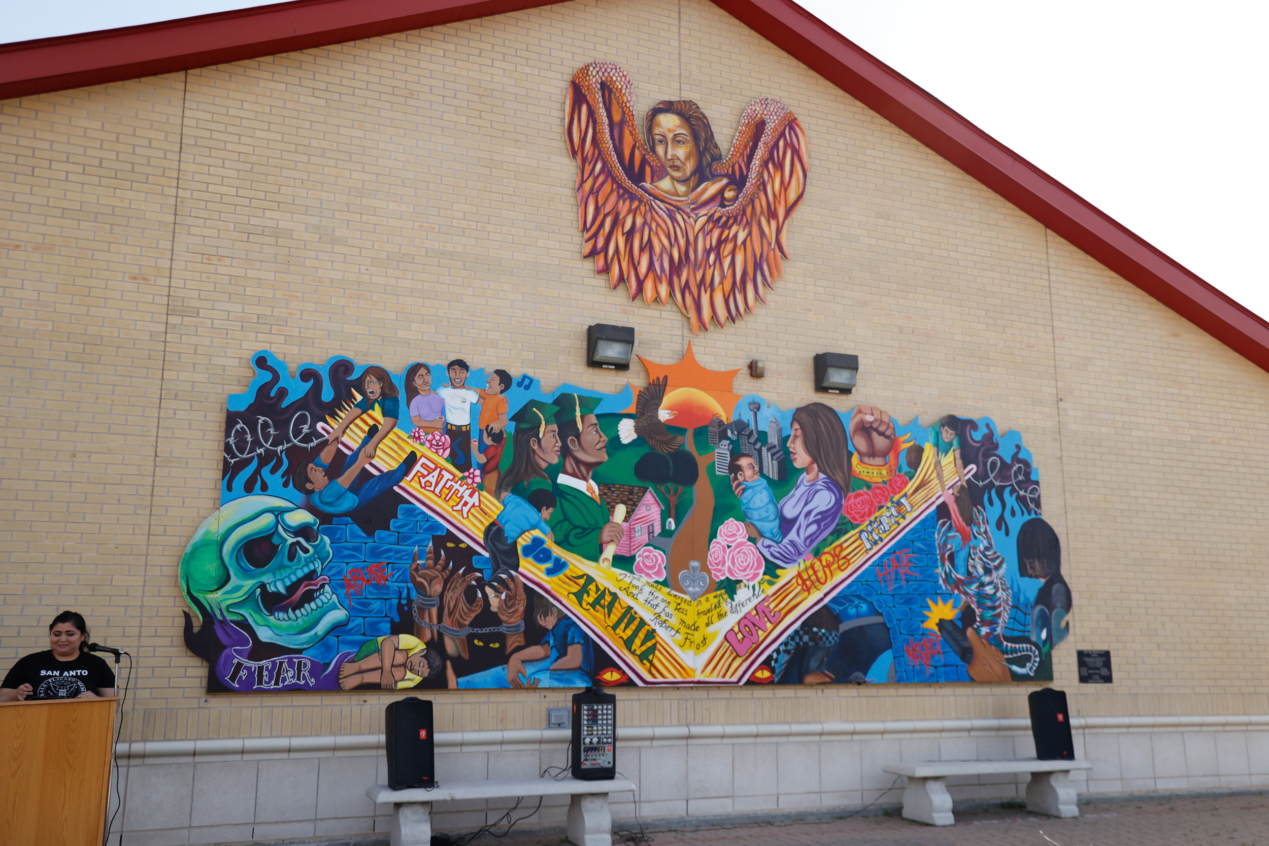 Woman at podium with mural