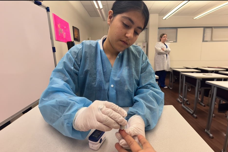 Girl doing finger prick in class