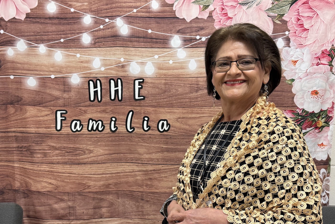Ms. Torres in front of HHE Familia sign