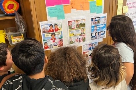 Students look at posters for mock election
