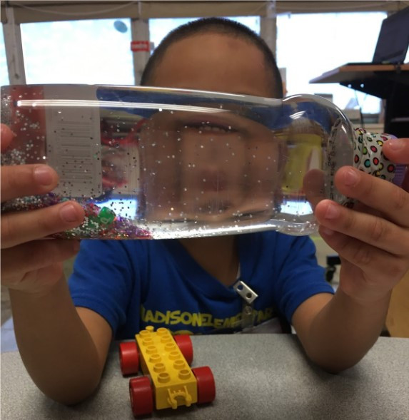 Student using a sensory bottle to practice self-regulation