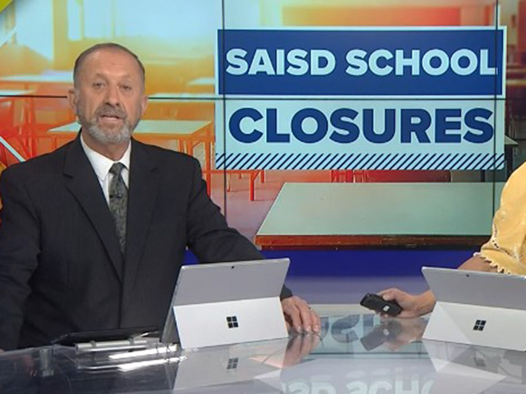 News anchor in front of a screen that says education