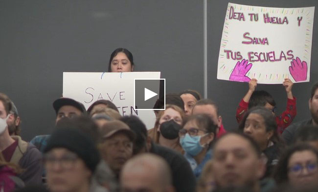 People holding signs at the November 13 SAISD Board Meeting