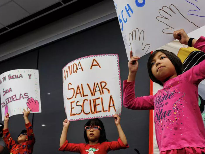 Students holding signs at school board meeting