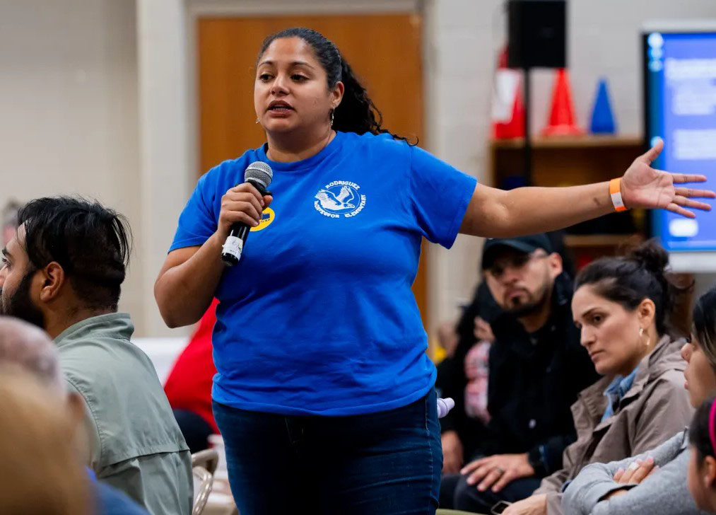 A woman stands and speaks at Rodriguez Montessori Neighborhood Meeting